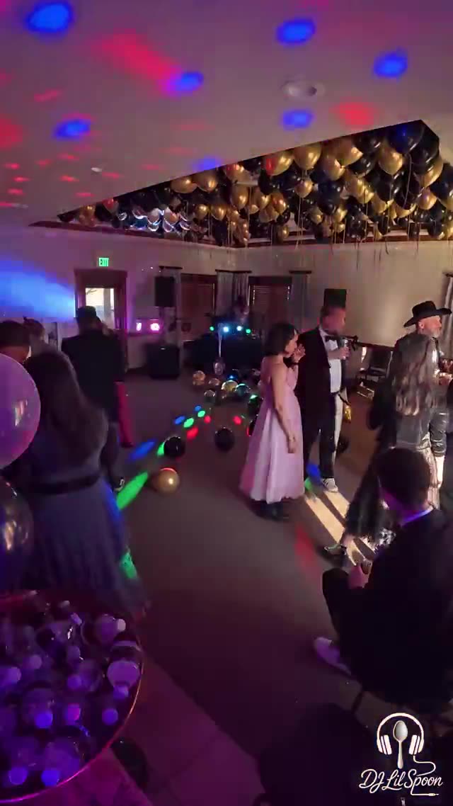 Students dancing under a full lighting rig at a school dance